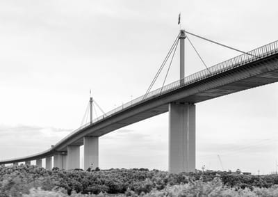 A large bridge with a modern design spanning over a landscape.